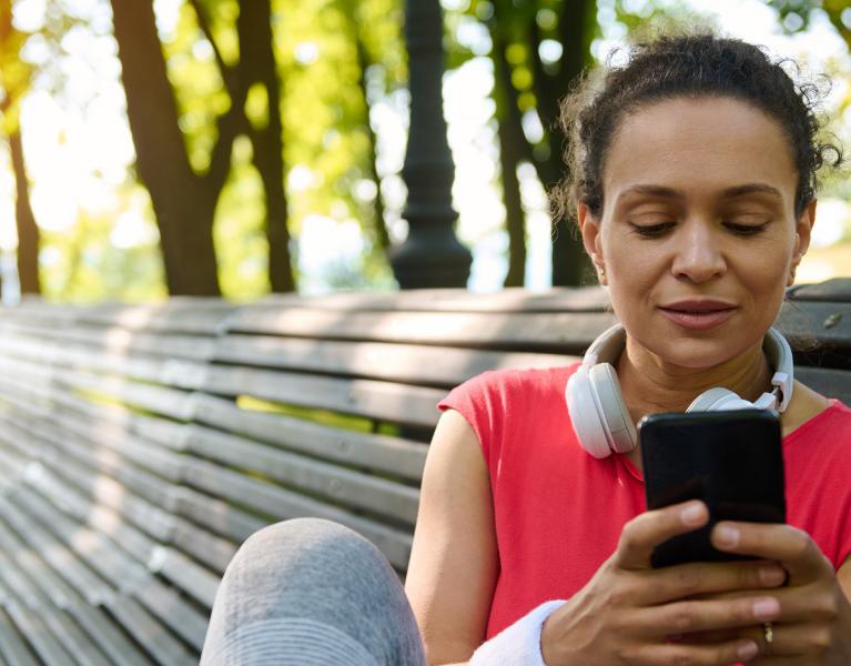 About PN header image, woman looking at health app on phone
